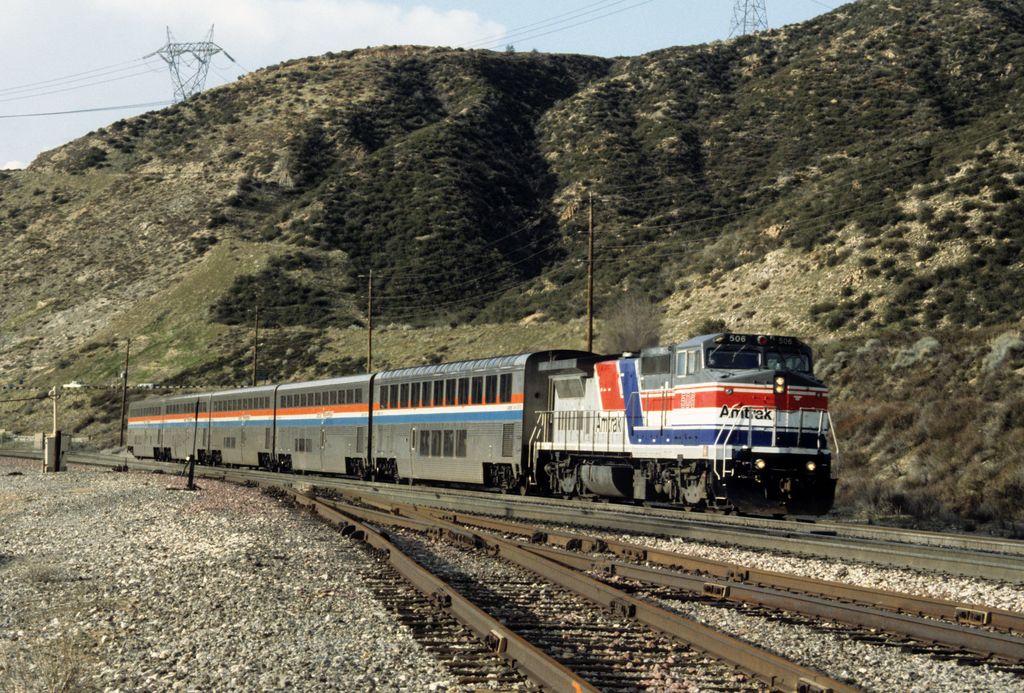 Amtrak train traversing the scenic hills of California along a railway track.